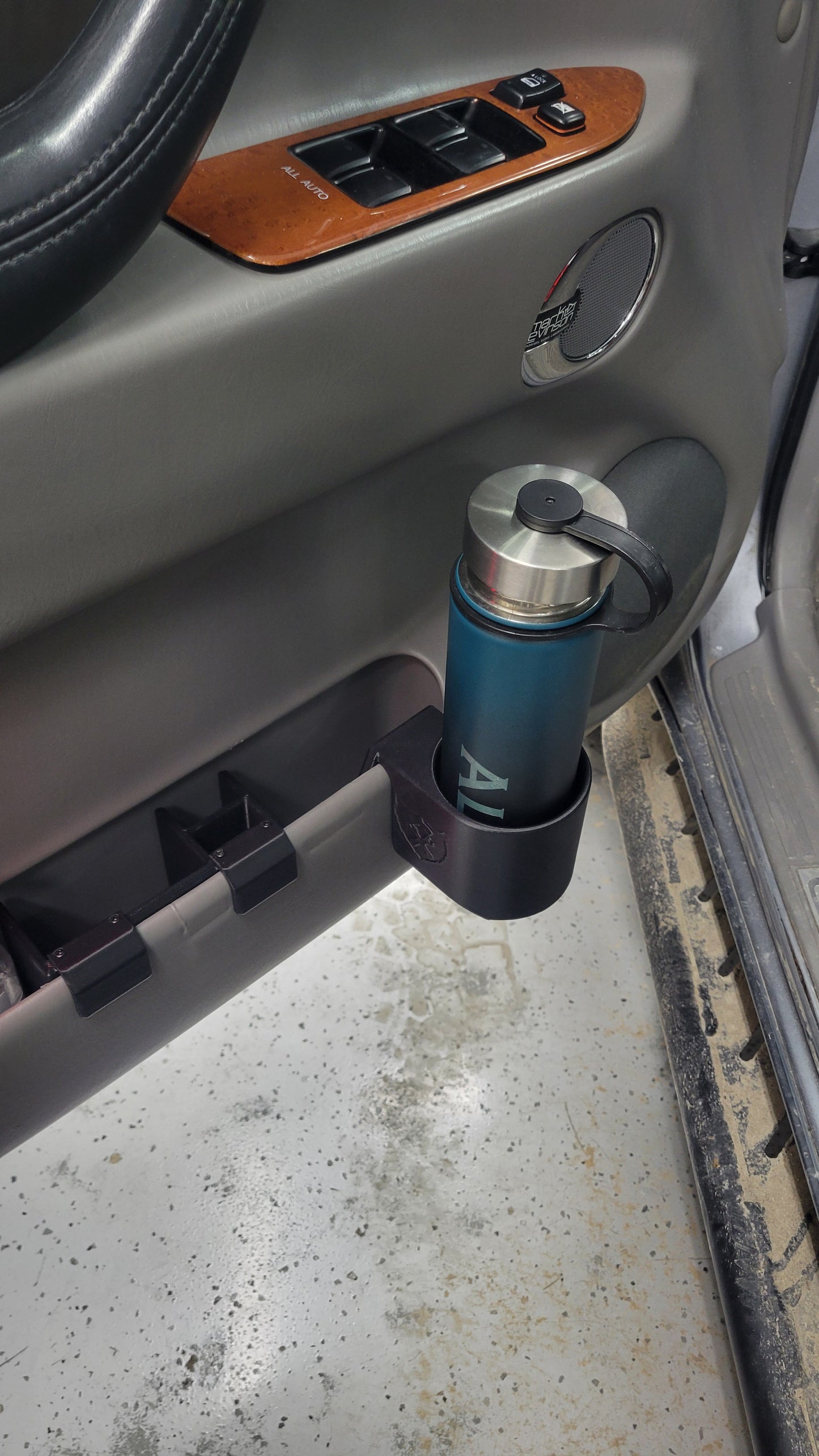 Close of up water bottle in Landcruiser/LX470 clip on door handle.